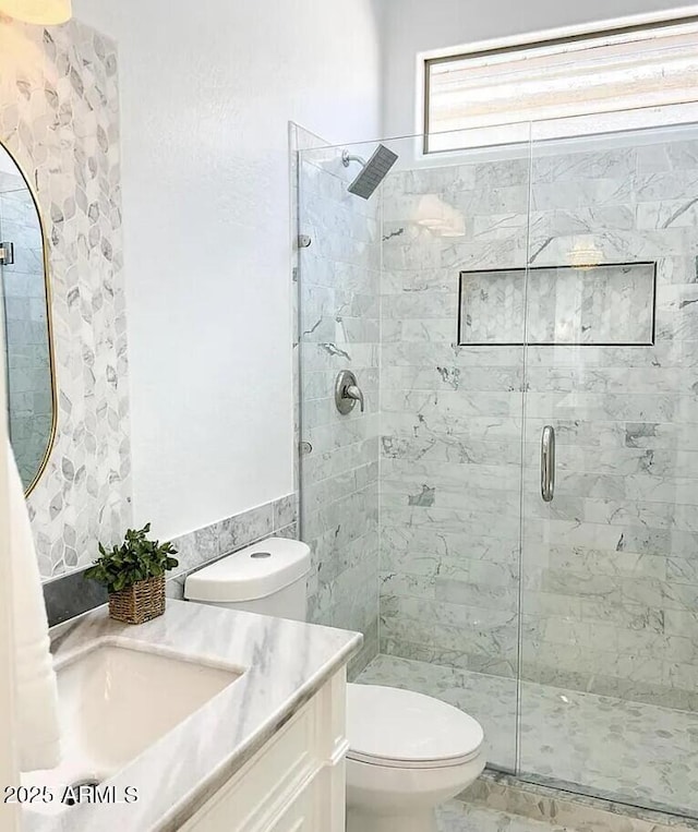 bathroom featuring walk in shower, vanity, and toilet