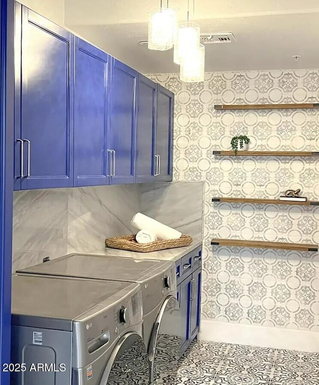 washroom featuring independent washer and dryer, cabinets, and light tile patterned flooring