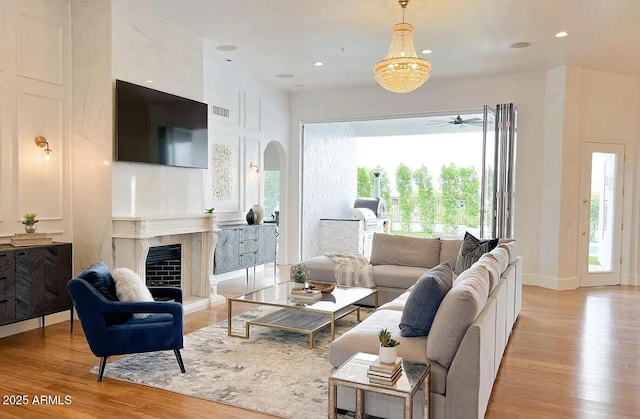 living room featuring a tiled fireplace and light hardwood / wood-style floors