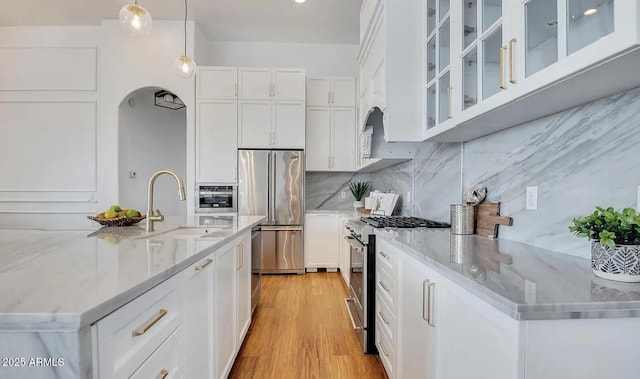 kitchen featuring pendant lighting, sink, white cabinets, and appliances with stainless steel finishes