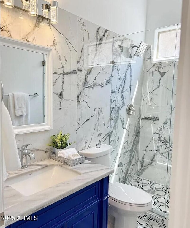 bathroom with vanity, tiled shower, tile walls, and toilet