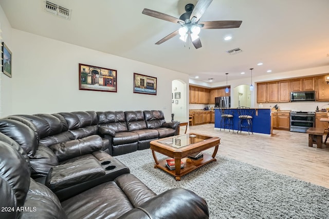 living room featuring ceiling fan and light hardwood / wood-style flooring