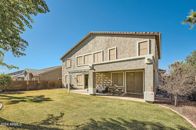 back of property with a lawn and a patio area