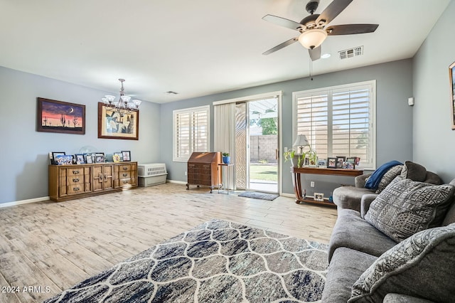 living room with wood-type flooring and ceiling fan with notable chandelier