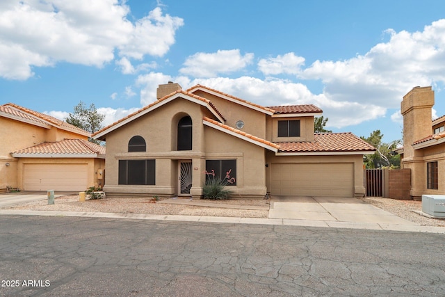 1344 N Brittany Ln, Gilbert, AZ 85233 - mediterranean / spanish-style house featuring driveway, a garage, stucco siding, a tile roof, and a chimney