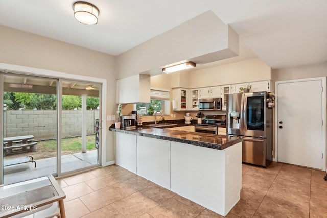 1344 N Brittany Ln, Gilbert, AZ 85233 - kitchen with stainless steel appliances, a sink, a peninsula, glass insert cabinets, and white cabinets