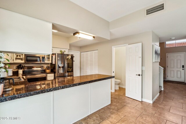 1344 N Brittany Ln, Gilbert, AZ 85233 - kitchen with appliances with stainless steel finishes, a peninsula, dark countertops, white cabinets, and light tile patterned flooring
