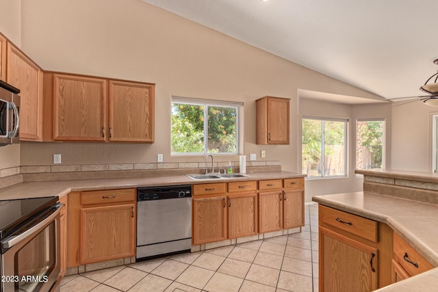 kitchen with dishwasher, sink, vaulted ceiling, range with electric stovetop, and light tile patterned flooring