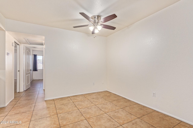 tiled spare room with ceiling fan