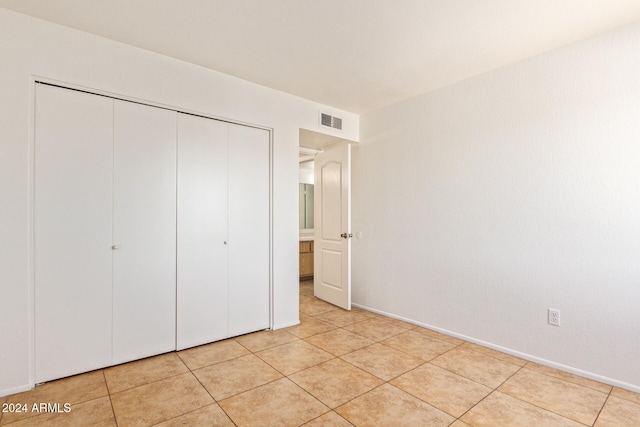 unfurnished bedroom with a closet and light tile patterned floors