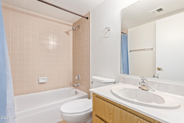 full bathroom with vanity, toilet, a textured ceiling, and shower / bath combo