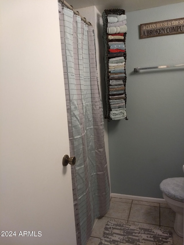 bathroom with tile patterned floors, toilet, and a shower with shower curtain