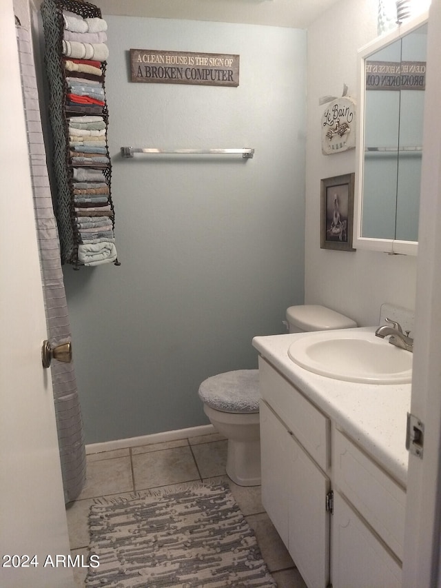 bathroom featuring tile flooring, toilet, and vanity