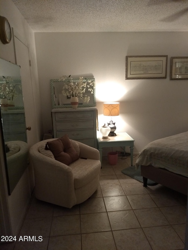 bedroom with tile floors and a textured ceiling