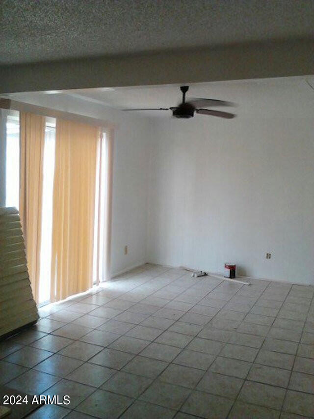 tiled spare room featuring ceiling fan and a textured ceiling