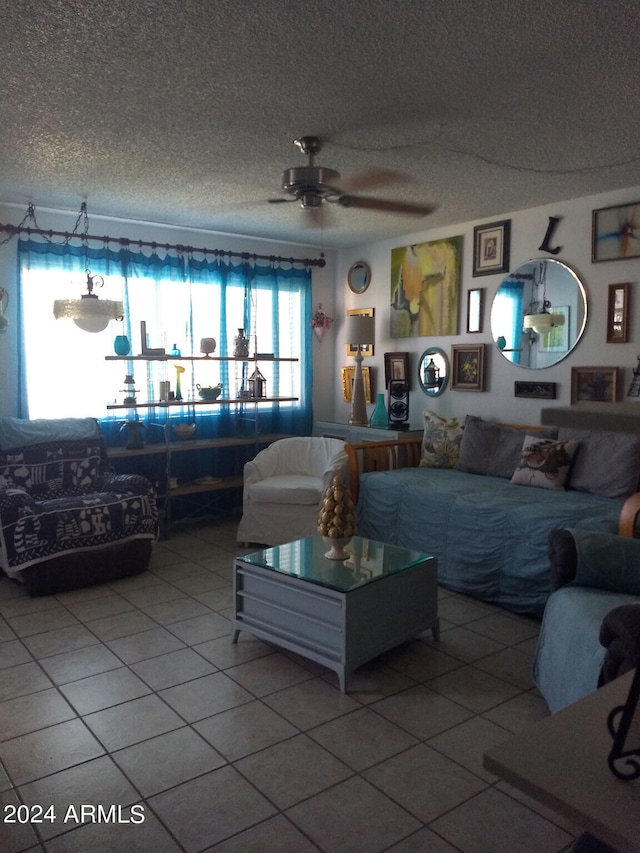 tiled living room featuring ceiling fan and a textured ceiling