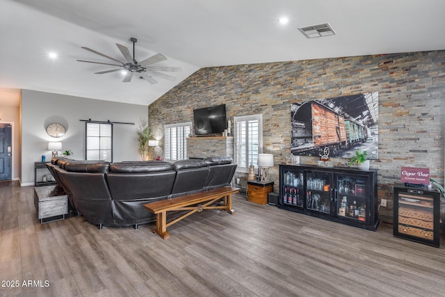 living area featuring visible vents, a barn door, a ceiling fan, recessed lighting, and wood finished floors