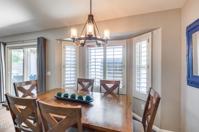 dining space featuring baseboards and a notable chandelier
