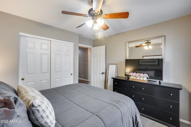 carpeted bedroom with a closet, baseboards, and a ceiling fan