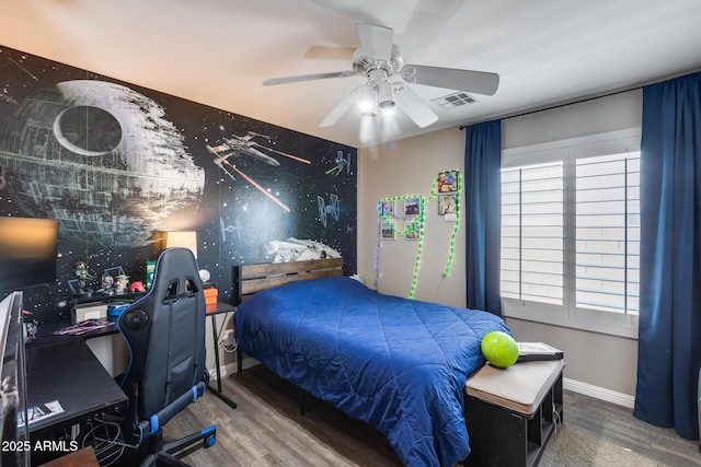 bedroom featuring visible vents, baseboards, a ceiling fan, and wood finished floors