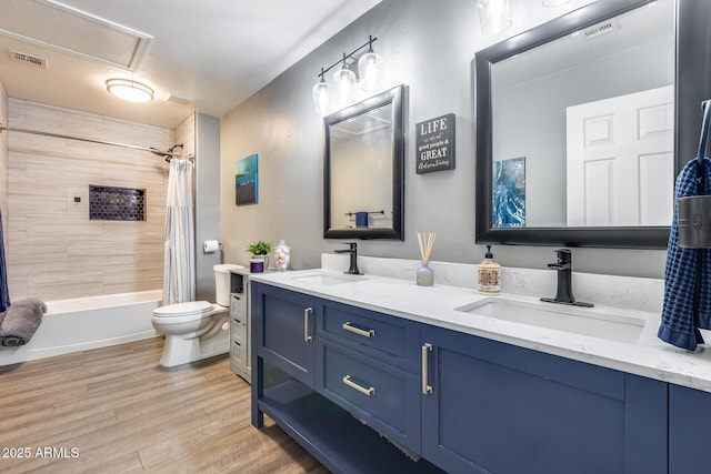 full bathroom with toilet, wood finished floors, a sink, and visible vents