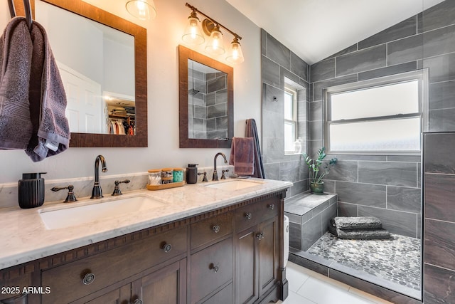full bathroom with a sink, double vanity, tile patterned flooring, and lofted ceiling