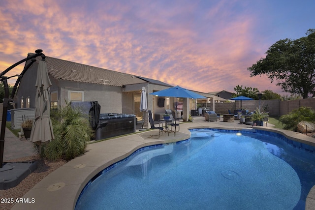 pool at dusk featuring a patio area, a fenced backyard, a jacuzzi, and a fenced in pool