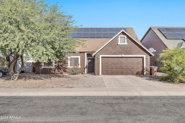 view of front of home featuring solar panels and a garage