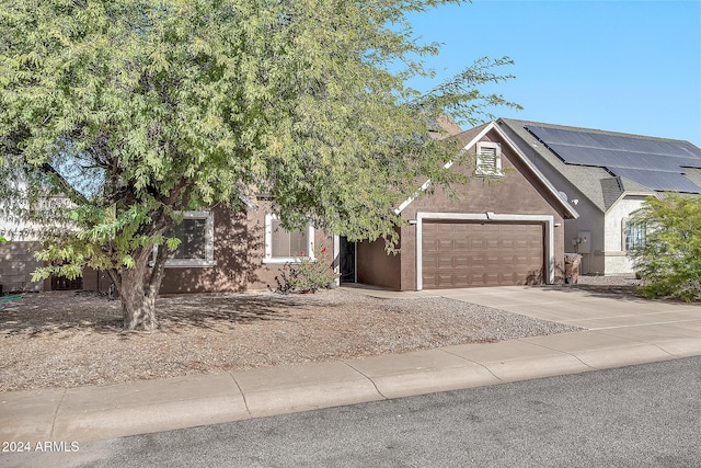 view of front facade featuring solar panels and a garage