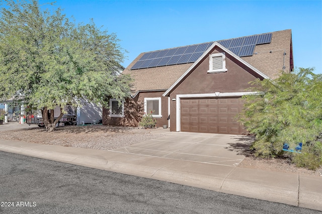 view of front of home with a garage and solar panels