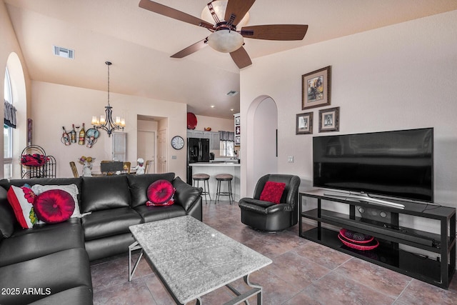 living room featuring ceiling fan with notable chandelier