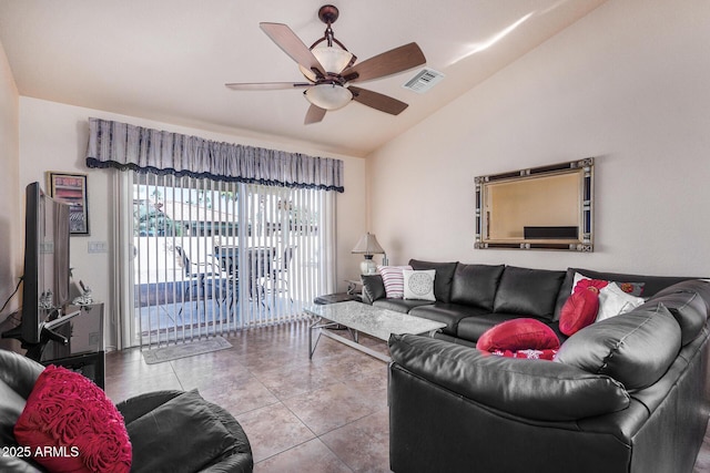 living room featuring ceiling fan, lofted ceiling, and tile patterned flooring