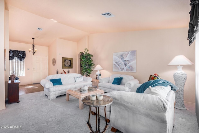 living room with vaulted ceiling, an inviting chandelier, and light carpet