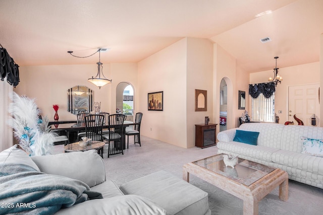 living room featuring light carpet, vaulted ceiling, and a notable chandelier