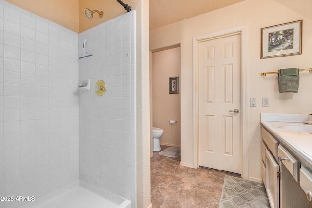 bathroom with toilet, vanity, and walk in shower