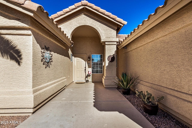 view of exterior entry with a patio area