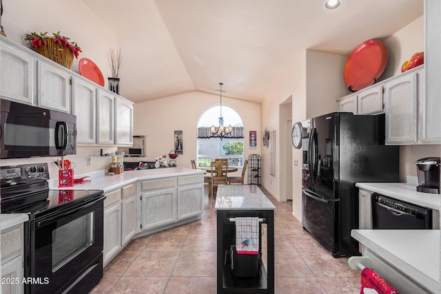 kitchen with vaulted ceiling, light tile patterned floors, decorative light fixtures, and black appliances