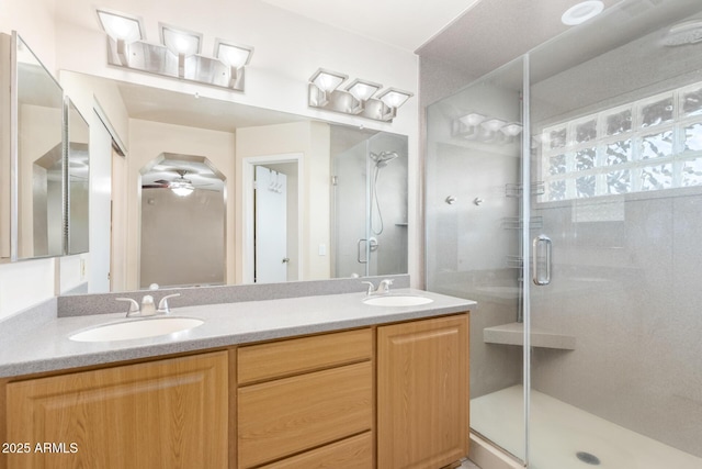 full bath featuring a stall shower, double vanity, a sink, and a ceiling fan