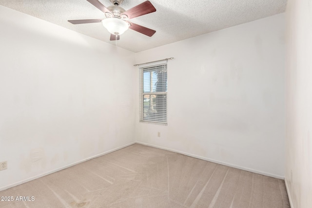 carpeted spare room with baseboards, ceiling fan, and a textured ceiling