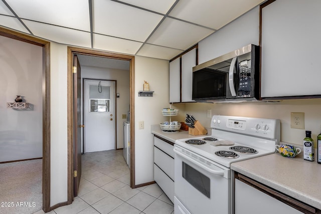 kitchen with electric stove, white cabinetry, a paneled ceiling, and light tile patterned floors