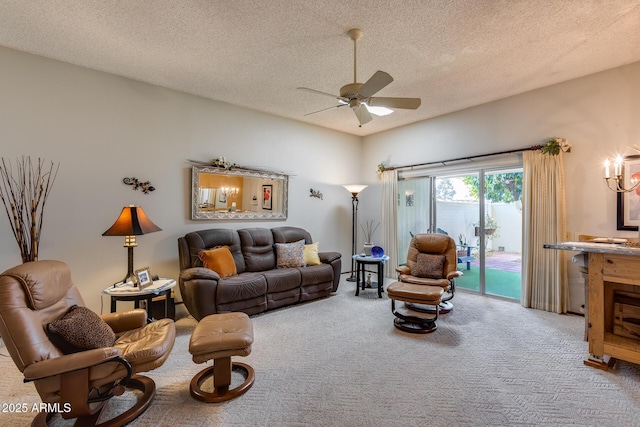 living room featuring ceiling fan, carpet flooring, and a textured ceiling