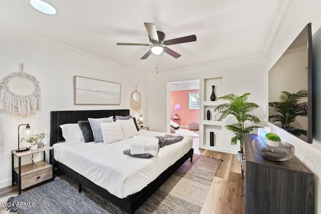 bedroom featuring ceiling fan, wood-type flooring, and crown molding