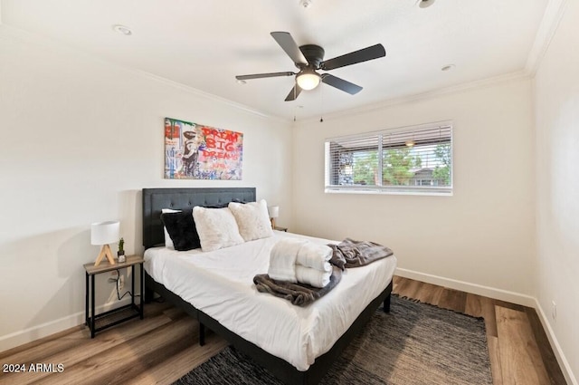 bedroom with hardwood / wood-style flooring, ceiling fan, and ornamental molding