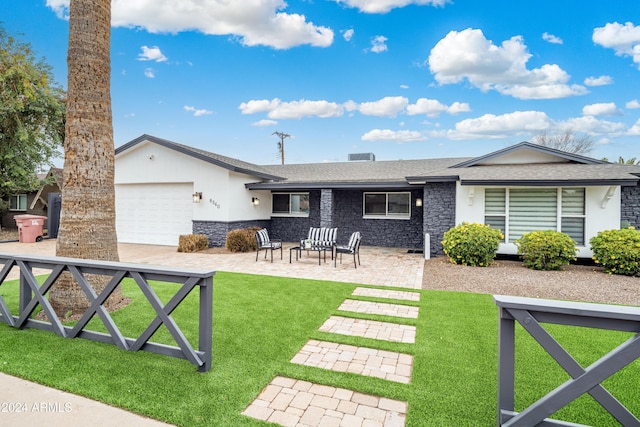 back of property featuring a lawn, a patio, and a garage