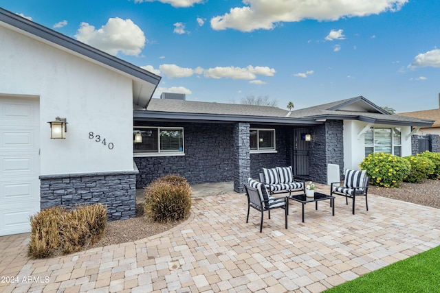 view of patio / terrace with an outdoor living space and a garage