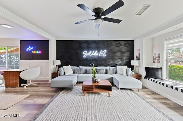 living room with light hardwood / wood-style flooring, ceiling fan, and crown molding