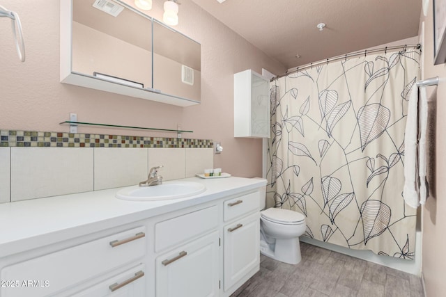 full bathroom with toilet, wood finished floors, vanity, visible vents, and decorative backsplash