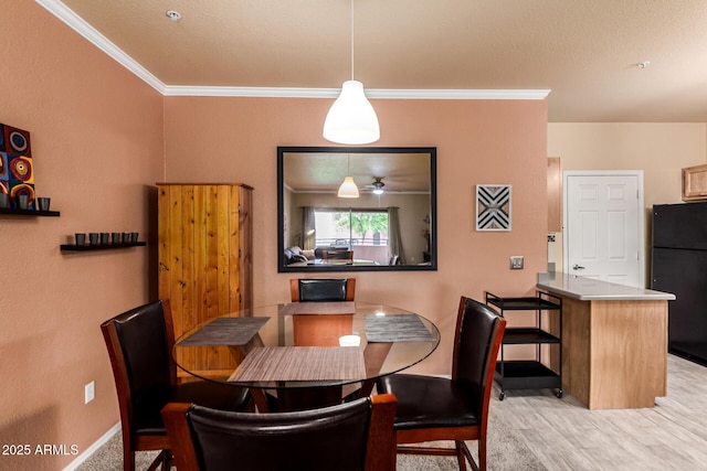 dining space with crown molding, baseboards, and wood finished floors