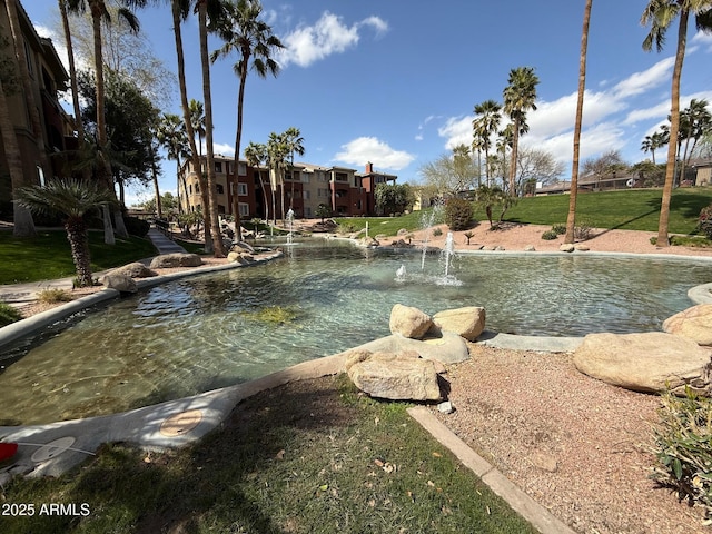 view of swimming pool featuring a yard