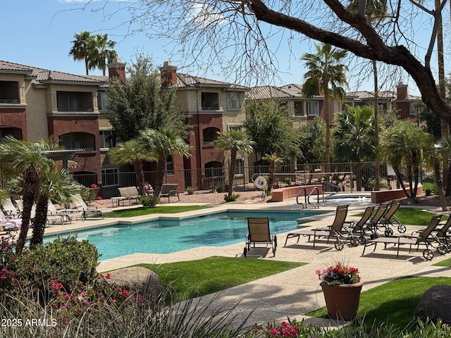 pool with a patio and fence